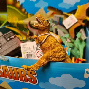 Stacked wooden pallet loaded with dinosaur‑themed toys and boxes, prepared for resale as a custom liquidation pallet.